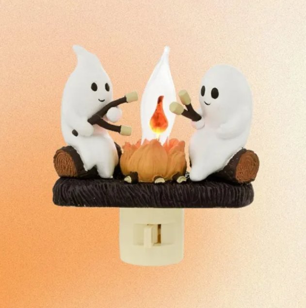 Nightlight featuring a ghost roasting s'mores at a campfire, creating a cozy, whimsical atmosphere